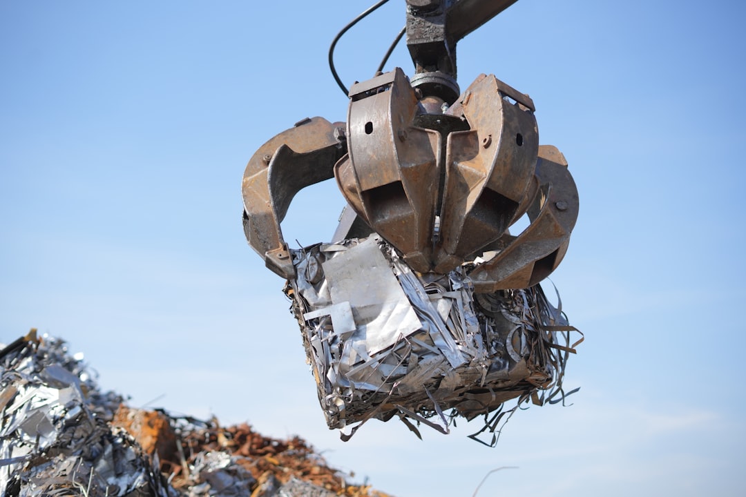 Industrial grapple lifting a compacted bale of metal scrap